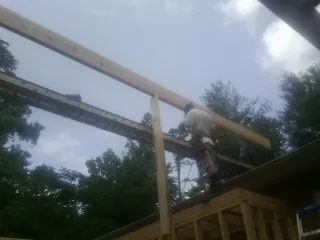 Carpenter setting a ridge beam over a new addition frame — Ice Dam Removal by Roofing Brothers in Eudora