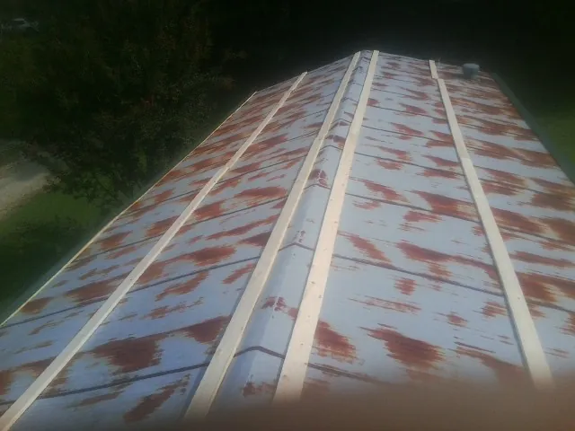Rusted metal roof panels with new wood purlins before replacement — Storm Damage Roof Repair in Eudora by Roofing Brothers