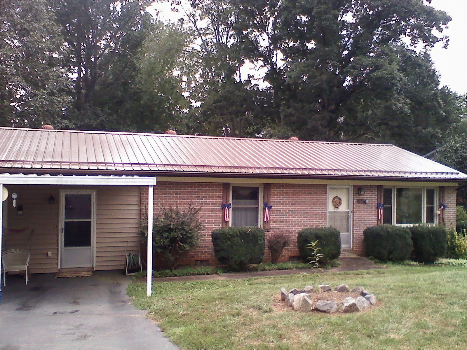 Bronze metal roof and carport on a brick ranch home — Roof Repair work by our crew in Eudora